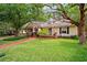 Charming home featuring a well-manicured lawn, cozy front porch, and mature trees at 3408 W San Jose St, Tampa, FL 33629