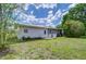 Back exterior with a small patio and well-maintained lawn, enclosed by a white picket fence at 39407 Rockford Ave, Zephyrhills, FL 33542