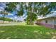 An expansive backyard with lush green grass, bordered by a brick-accented building at 39407 Rockford Ave, Zephyrhills, FL 33542
