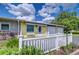 Inviting front entrance with a decorative door, small garden, and a white picket fence leading to a two-car garage at 39407 Rockford Ave, Zephyrhills, FL 33542