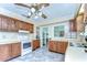 Traditional kitchen boasts wood cabinets, white appliances, and neutral countertops and flooring at 39407 Rockford Ave, Zephyrhills, FL 33542