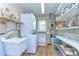 Functional laundry room with washer, dryer, sink, and shelving for organized storage at 39407 Rockford Ave, Zephyrhills, FL 33542
