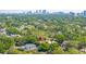 Sweeping aerial view of home with lush landscaping and a distant cityscape at 4010 W Leona St, Tampa, FL 33629