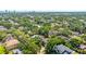 Aerial view of home, landscaped backyard, pool, mature trees, and neighborhood at 4010 W Leona St, Tampa, FL 33629