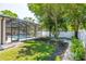 Serene backyard with screened-in pool, lush lawn, and privacy landscaping at 4010 W Leona St, Tampa, FL 33629