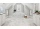 Bright bathroom featuring soaking tub with marble surround, tile flooring, and neutral color palette at 4010 W Leona St, Tampa, FL 33629