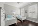 Bright bedroom features wood floors, two beds, and two windows with modern blinds at 4010 W Leona St, Tampa, FL 33629