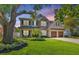Charming two-story home featuring a well-manicured lawn, mature trees, and a two-car garage at 4010 W Leona St, Tampa, FL 33629