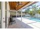 Screened-in pool area with wood ceiling, tiled patio, and outdoor furniture at 4010 W Leona St, Tampa, FL 33629