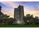 Stunning exterior view of a high-rise building set against a beautiful sunset sky with lush landscaping in the foreground at 4141 Bayshore Blvd # 306, Tampa, FL 33611