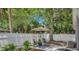 Backyard shaded by mature trees, featuring a patio seating area with chairs and a shade umbrella at 4527 24Th S Ave, St Petersburg, FL 33711