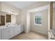 Bright bathroom featuring double sinks, white cabinets, and a large arched window offering natural light at 4538 Appleton Ter, North Port, FL 34286