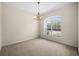 Bright dining room featuring carpet floors, a modern chandelier and a large arched window for natural light at 4538 Appleton Ter, North Port, FL 34286