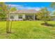 Serene backyard with green lawn, privacy fence, and a screened patio for outdoor enjoyment at 4581 Majestic Hills Loop, Brooksville, FL 34601