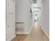 Hallway with light wood floors leading to open rooms, featuring natural lighting and neutral paint at 4581 Majestic Hills Loop, Brooksville, FL 34601