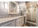 Bright bathroom featuring a double sink vanity with white cabinets, a marble countertop, and a glass door shower at 5010 Umber N Way, Tampa, FL 33624