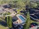 Aerial view of the community pool, lounge chairs, parking, and landscaping at this townhome community near a pond at 5010 Umber N Way, Tampa, FL 33624
