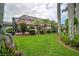 Manicured backyard featuring a screened pool area, palm trees, and decorative yard art at 5519 Greyston St, Palm Harbor, FL 34685
