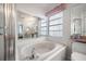 Bright bathroom features walk-in shower, bathtub, toilet, and a vanity area with mirror and drawers at 5519 Greyston St, Palm Harbor, FL 34685