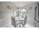 Cozy dining area with a round glass table, complemented by a large arched window and light fixture at 5519 Greyston St, Palm Harbor, FL 34685