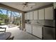 Open-air kitchen featuring ample cabinet storage, a refrigerator, and a beautiful view of the screened lanai at 5519 Greyston St, Palm Harbor, FL 34685