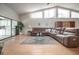Bright living room with a sectional sofa, tall windows and an open floor plan to kitchen at 5519 Greyston St, Palm Harbor, FL 34685