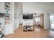Bright living room with hardwood floors, built in shelving and large TV, opening to bedrooms at 5519 Greyston St, Palm Harbor, FL 34685