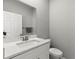 Bathroom with white marble vanity, a large mirror, and a white toilet at 6406 Sanctuary Creek Ln, Tampa, FL 33625