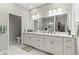 Bright bathroom with double sinks, white cabinets, and large framed mirror at 6406 Sanctuary Creek Ln, Tampa, FL 33625