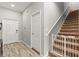 Home entryway featuring wood floors, staircase with baby gate, and white interior doors at 6406 Sanctuary Creek Ln, Tampa, FL 33625