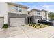 Neutral-toned townhome with garage, complemented by landscaped front and a blue sky above at 6406 Sanctuary Creek Ln, Tampa, FL 33625
