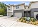 Two-story townhome featuring a one-car garage and neutral-toned siding with gray accents at 6406 Sanctuary Creek Ln, Tampa, FL 33625