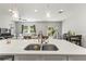 Modern kitchen features an island with white countertop, a sink and open view to the living room at 6406 Sanctuary Creek Ln, Tampa, FL 33625