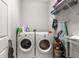 Functional laundry room with washer, dryer, and shelving for organized storage solutions at 6406 Sanctuary Creek Ln, Tampa, FL 33625