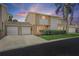 Charming townhouse featuring a two-car garage, well-maintained landscaping, and inviting curb appeal under a beautiful sunset sky at 6490 Cape Hatteras Ne Way # 4, St Petersburg, FL 33702
