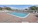 Community swimming pool surrounded by brick decking, lounge chairs, and a white fence at 6490 Cape Hatteras Ne Way # 4, St Petersburg, FL 33702