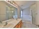 Bright bathroom featuring a double sink vanity, soaking tub, and a separate glass-enclosed shower at 6933 Waterbrook Ct, Gibsonton, FL 33534