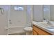 Clean bathroom featuring white tile, a soaking tub and a wooden vanity with white countertops at 6933 Waterbrook Ct, Gibsonton, FL 33534