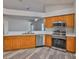 Well-lit kitchen with stainless steel appliances and updated flooring, seamlessly flowing into the adjacent living space at 6933 Waterbrook Ct, Gibsonton, FL 33534