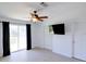 Bedroom with sliding glass doors to deck, ceiling fan, and a mounted TV at 7647 Navigator Ct, Port Richey, FL 34668