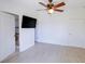 Bedroom with hardwood floors, ceiling fan, and ensuite bathroom entrance at 7647 Navigator Ct, Port Richey, FL 34668