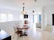 Open-concept dining area featuring tile flooring, white walls, modern lighting, and comfortable seating at 7647 Navigator Ct, Port Richey, FL 34668