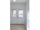 Entryway features a glass front door and tan tile flooring, with natural light streaming through at 7647 Navigator Ct, Port Richey, FL 34668