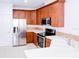 Bright kitchen with stainless appliances, wood cabinets, and tile flooring, offering functionality and style at 7647 Navigator Ct, Port Richey, FL 34668