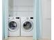 Laundry area featuring side-by-side washer and dryer with blue curtains at 7647 Navigator Ct, Port Richey, FL 34668