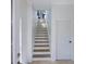 Bright stairway with neutral-toned stairs, white walls, and a closed door, providing access to upper levels at 7647 Navigator Ct, Port Richey, FL 34668