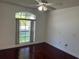 Bedroom showcasing large window, ceiling fan, and rich hardwood flooring at 8908 Southbay Dr, Tampa, FL 33615