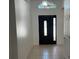 Bright entryway with tile flooring and decorative front door with transom window above at 8908 Southbay Dr, Tampa, FL 33615