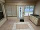 Sunroom with tiled flooring and multiple windows, featuring a convenient counter with cabinets at 8908 Southbay Dr, Tampa, FL 33615