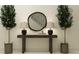 Stylish entryway featuring olive trees, a round mirror, and a wooden console table with decor at 9348 Gladsome Dr, Land O Lakes, FL 34637